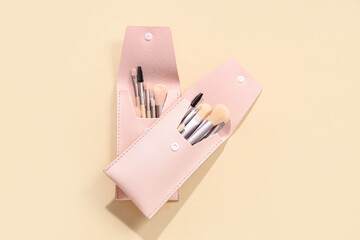 Wall Mural - Different stylish makeup brushes in cases on beige background