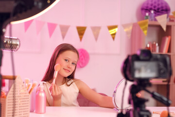 Poster - Teenage beauty blogger with makeup brush and mirror recording video at table in bedroom