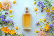 © MadMouse - Bottle of perfume with beautiful different flowers on blue background, flat lay