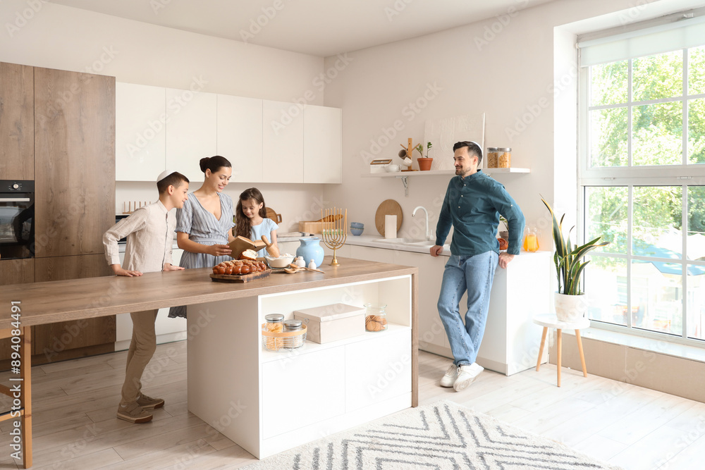 Happy Jewish family reading book in kitchen