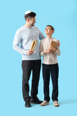 Poster - Happy Jewish father and his little son with books on blue background