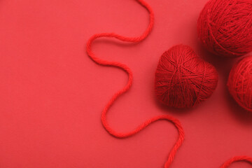 Poster - Composition with balls of knitting yarn on red background