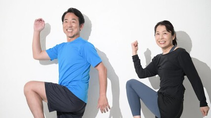 Wall Mural - スポーツや健康などをする50代の夫婦の上半身　笑顔でストレッチをするスロー動画