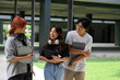 © Parichat - Group of Happy Students Socializing Outdoors on Campus with Tablets and Headphones