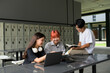 © Parichat - Group of Diverse Students Studying Together with Laptops and Books in a Modern School Setting