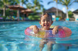 © AspctStyle - Joyful young girl laughing and floating with a colorful inflatable ring in a bright blue pool, vibrant resort background