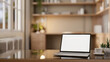 © bongkarn - A laptop with a mockup screen on a modern coffee table in a cozy private office workspace.