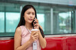 © bongkarn - A thoughtful Asian businesswoman is talking on the phone while commuting to work on the sky train.