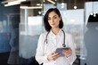 © Liubomir - Female doctor with stethoscope using tablet in modern office. Professional poses with confident expression. Technology and healthcare concept. Bright, contemporary medical environment.