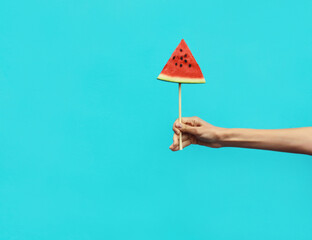 Wall Mural - Summer of woman holding sweet lollipop or ice cream shaped slice of watermelon, hands showing fruit