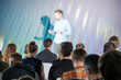 © Anton Gvozdikov - Speaker gives a presentation to a seated audience during a business conference, focusing on professional development and learning.
