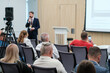 © Anton Gvozdikov - Business presentation held in conference room with speaker addressing audience, recorded by camera.