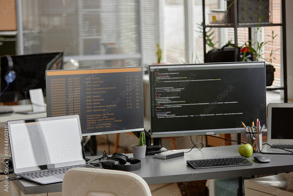 Background shot of empty programmer desk setup with laptop and multiple ...