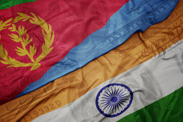 Wall Mural - waving colorful flag of india and national flag of eritrea on the dollar money background. finance concept.