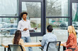 © LIGHTFIELD STUDIOS - A man presenting to a group of people in an office setting.