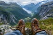 © mediahain.de - A hiker's boots on a mountain trail, with a breathtaking view of the valley below