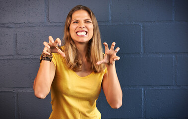 Woman, happy portrait and hand claws with mockup, fun entertainment and wellness by brick wall. Female person, excited smile and animal gesture with space, scratch and isolated by dark background