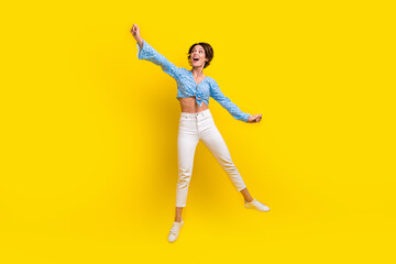 Poster - Full size photo of impressed nice woman wear print blouse flying catching object in empty space isolated on yellow color background