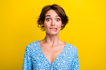 Wall Mural - Photo of doubtful unsure young lady dressed flower print top biting lip isolated yellow color background