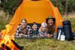 © ronstik - happy family with kids camping in the forest. laying and relaxing in tent