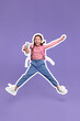 © New Africa - Happy school child with backpack jumping on violet background