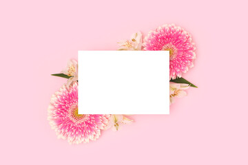 Wall Mural - blank paper mock up. frame made of green leaves, alstroemeria and pink gerbera flowers on a pink bac