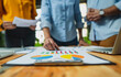 © Teeraphon - Professional business team working on a project together in the office Using economic growth charts and network connections to accompany the data. in analyzing future trends