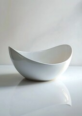 A pristine white porcelain bowl with a simple yet elegant design placed on a white surface The bowl's smooth curves and clean lines are accentuated by the minimalistic background