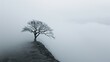 © svastix - A lone tree stands on a foggy hilltop, creating an atmosphere of serene solitude and introspection in a minimalist and calm artistic style image.