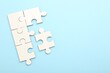 © New Africa - White puzzle pieces on light blue background, top view. Space for text