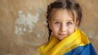 © Akmalism - Happy little girl with Ukrainian flag on beige background.