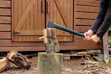 Hands and axe in firewood, man chopping wood for fire heat, preparing firewood for winter