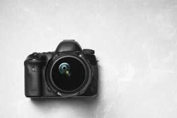 Canvas Print - Modern photo camera on light grey marble table, top view. Space for text