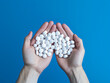 © Llama-World-studio - Pills held in hand, medical concept, close-up on blue background
