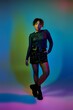 © LIGHTFIELD STUDIOS - A vibrant African American woman striking a pose in a short skirt paired with stylish boots.