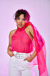 © LIGHTFIELD STUDIOS - African American woman poses gracefully in pink top and white pants against vibrant backdrop.