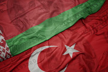 Wall Mural - waving colorful flag of belarus and national flag of turkey on the dollar money background. finance concept.