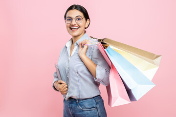 Wall Mural - Cheerful woman wearing glasses shirt and jeans holding digital tablet and shopping bags