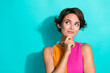 © deagreez - Photo of charming thoughtful lady dressed colorful top arm chin looking empty space isolated turquoise color background