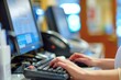 © Elena - Receptionist typing on a computer at a desk with a keyboard and monitor in focus