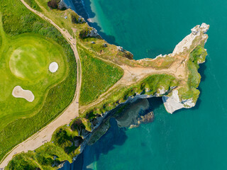 Wall Mural - Aerial view of Etretat cliffs and the Atlantic ocean. Chalk cliffs and three natural arches. Panoramic path to admire the coast. Normandy region of Northwestern France. 06-26-2024