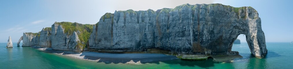 Wall Mural - Aerial view of Etretat cliffs and the Atlantic ocean. Chalk cliffs and three natural arches. Panoramic path to admire the coast. Normandy region of Northwestern France. 06-26-2024