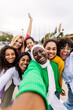 © Xavier Lorenzo - Vertical photo of happy young group of diverse women taking selfie portrait at city street. Female community and friendship concept.