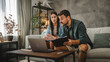 © Miljan Živković - couple work from home on laptop and have video call consultation