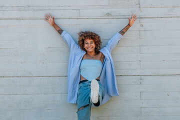 Wall Mural - happy funny girl smiling on the street isolated on wall