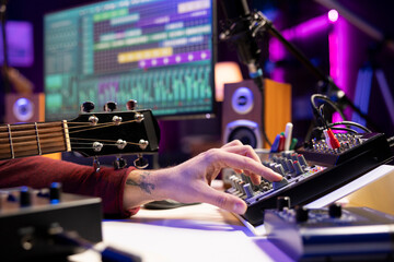 Aufkleber - Sound engineer using mixing console and acoustic guitar in home studio, adjusting volume levels in post production editing. Music producer creating soundtracks, twisting pre amp knobs.