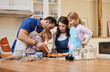 © CineLens2024/peopleimages.com - Cupcake, baking and parents with kids in kitchen with ingredients for bonding, learning and fun together. Family, home and mom, dad and girls help with recipe for cake, dessert and school bakery sale