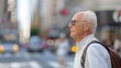 © LifeMedia - An elderly man wears a backpack and crosses a busy city street in the afternoon, symbolizing urban life and the contrasts between age and the bustling environment.