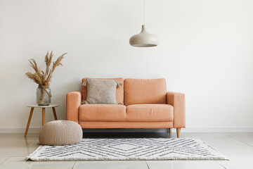 Grey sofa with cushion and pampas grass on coffee table in light living room