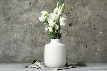 Wall Mural - Vase with white eustoma flowers on grunge background